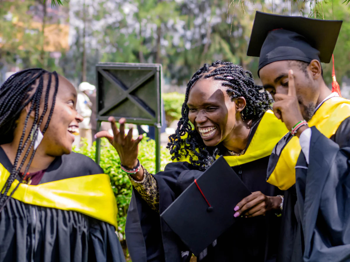 Smiling African students in graduation gowns celebrating together